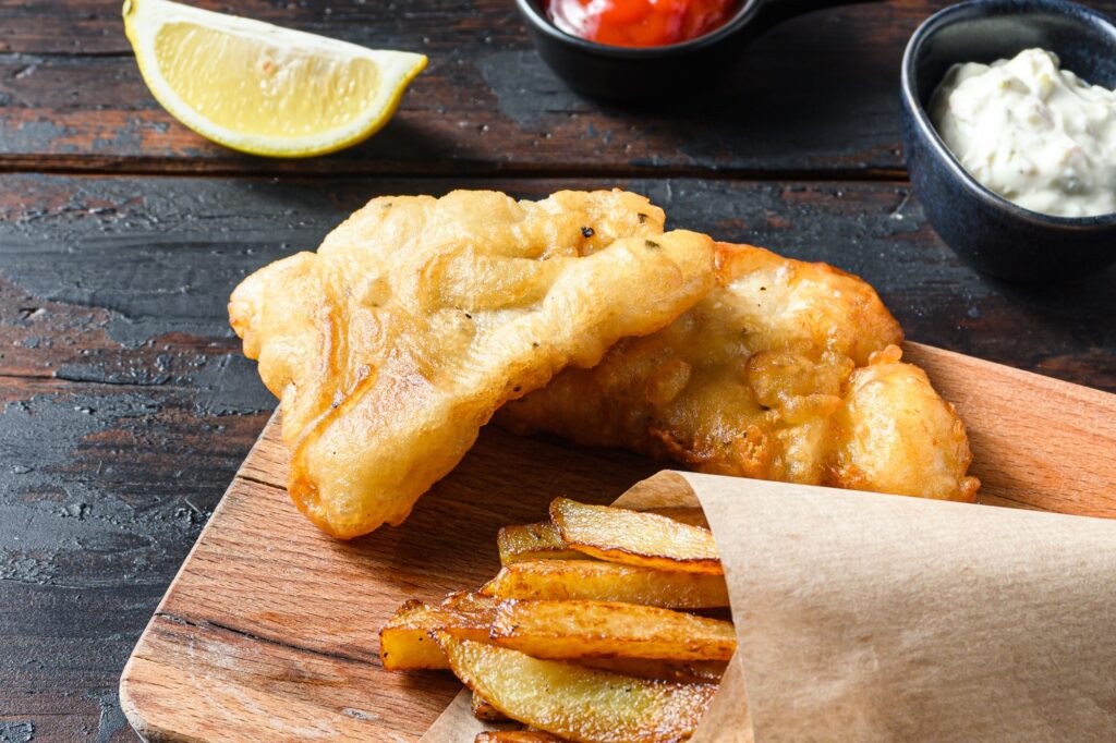 Fish and chips with tartar sauce, ketchup, and a slice of lemon